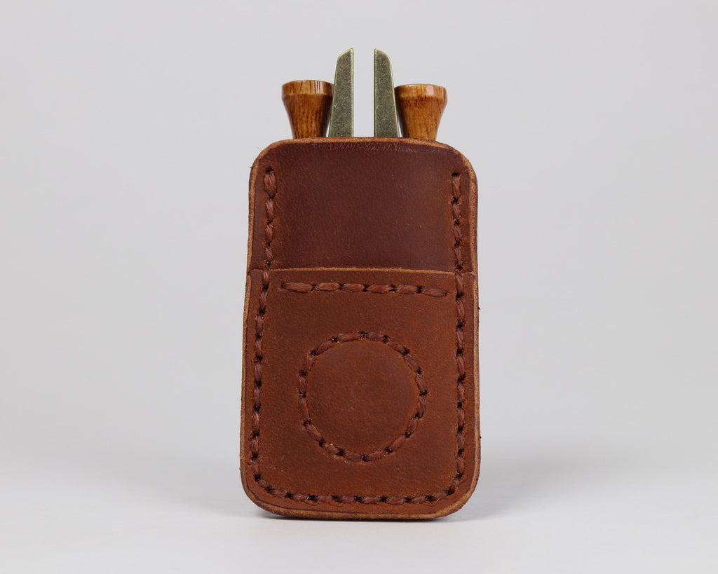 Compact leather golf organizer designed to keep tees, a divot tool, and a ball marker within reach.