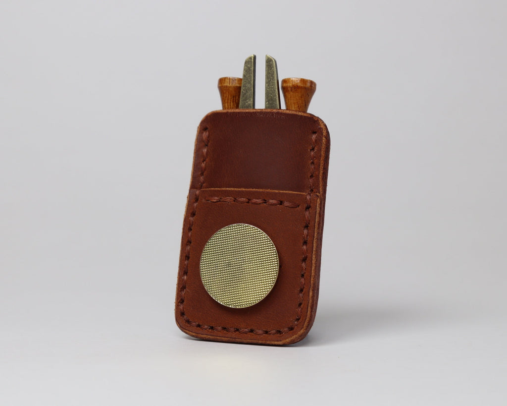 Premium full grain chestnut brown leather golf pocket caddy designed to hold tees, a divot tool, and a magnetic ball marker.